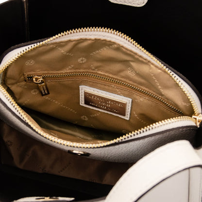 Interior view of beige handbag with tan lining gold zip pocket and brand label.