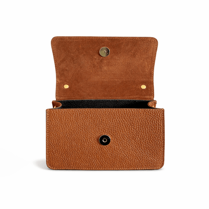 Inside of a brown leather handbag with gold magnetic button on a white background