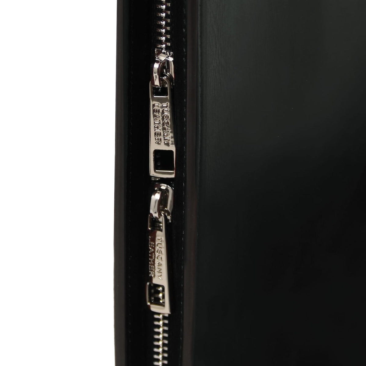 Primer plano of twin silver zippers on the Tiberio leather document case