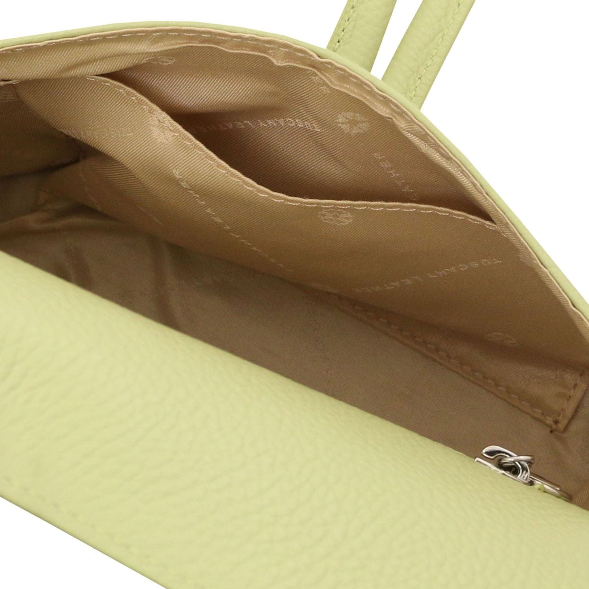 Vue intérieure of vert citron foldover leather clutch with doublure cognac and inner pocket