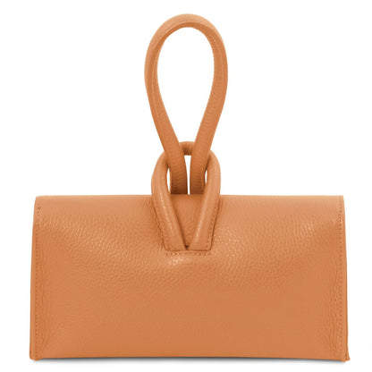 Gros plan of cognac leather foldover clutch highlighting the double loop poignée supérieure and wrapped strap