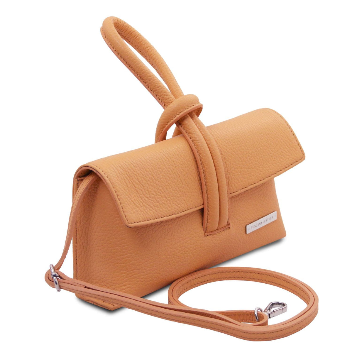 Three quarter view of cognac leather foldover clutch with attached shoulder strap and wraparound loop