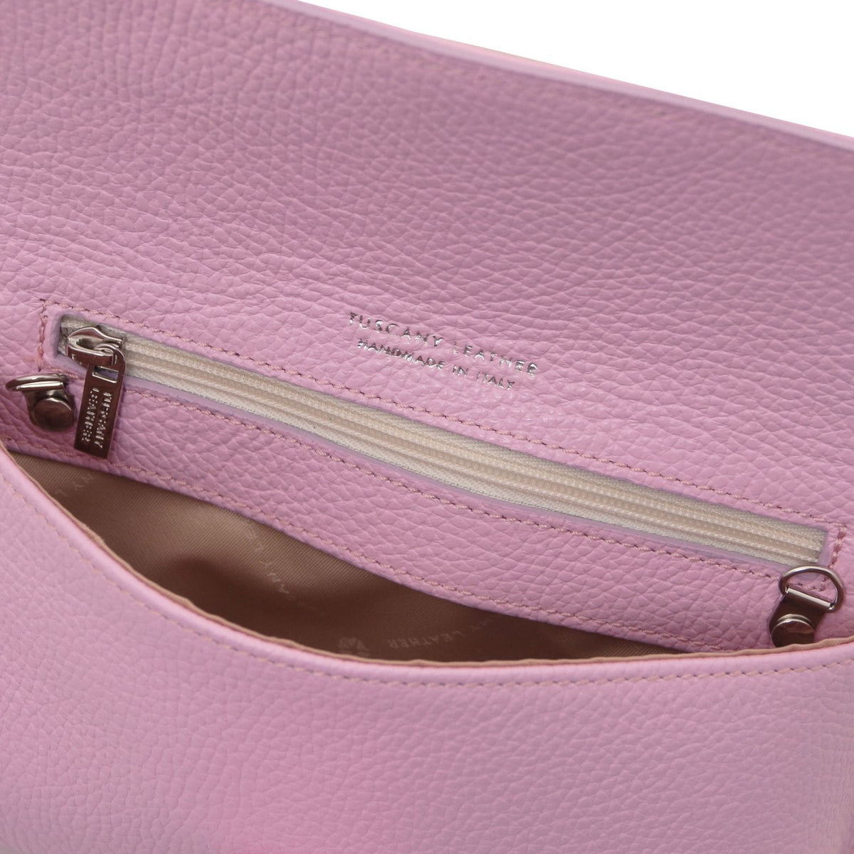 Vue intérieure of pink leather clutch with poche zippée and doublure cognac
