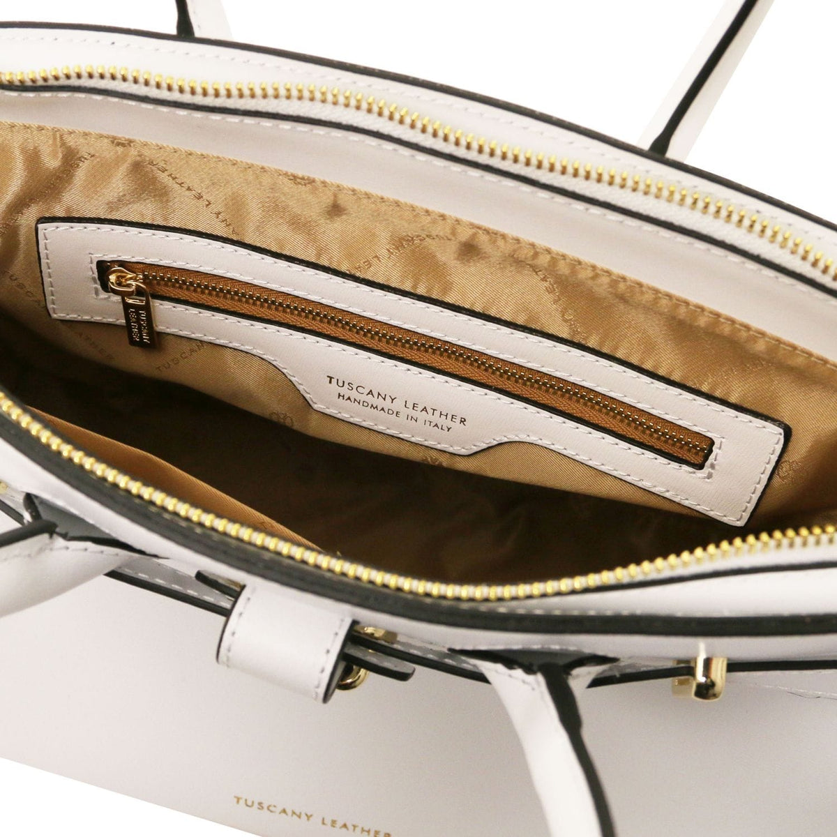 Vista interior of white leather handbag with golden zipper pocket and cuero forro de tela, handcrafted in Italy.