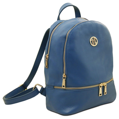 Blue cuir souple backpack with fermetures zippées dorées and circular logo doré on the front