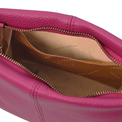 Nahaufnahme of a pink weiches Leder shoulder bag showing the interior with mehrere Fächer and a zipper closure.