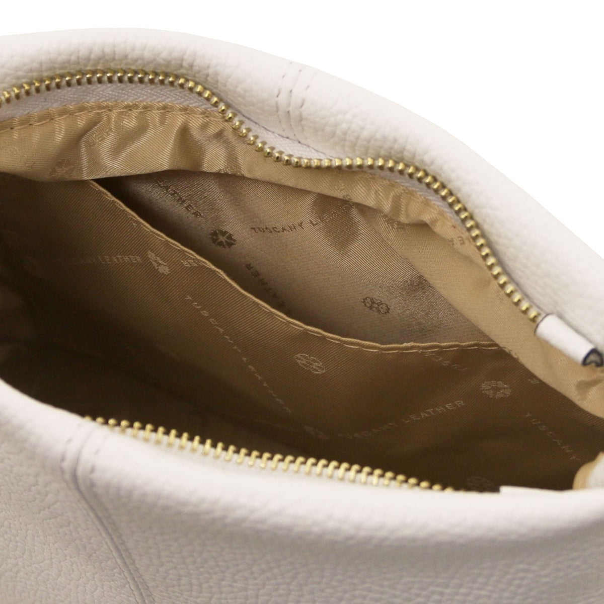 Nahaufnahme of soft white leather bag interior with beige Stofffutter and goldfarbener Reissverschluss detailing.