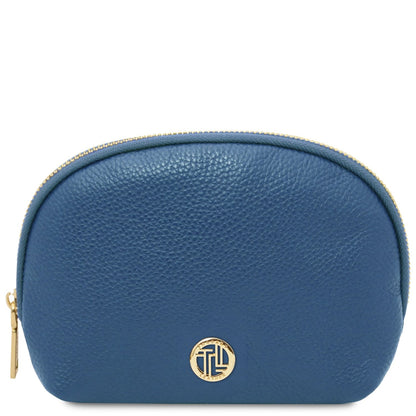 Compact blue piel granulada toiletry case with gold-tone zipper and circular metal emblem on front panel.
