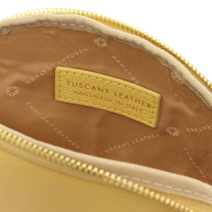 Primer plano of piel suave toiletry case interior showing forro de tela and stitched Tuscany Leather label inside zipper opening.