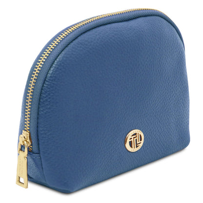 Blue piel suave toiletry case with gold-tone zipper and round metal emblem on pebbled Italian leather surface.