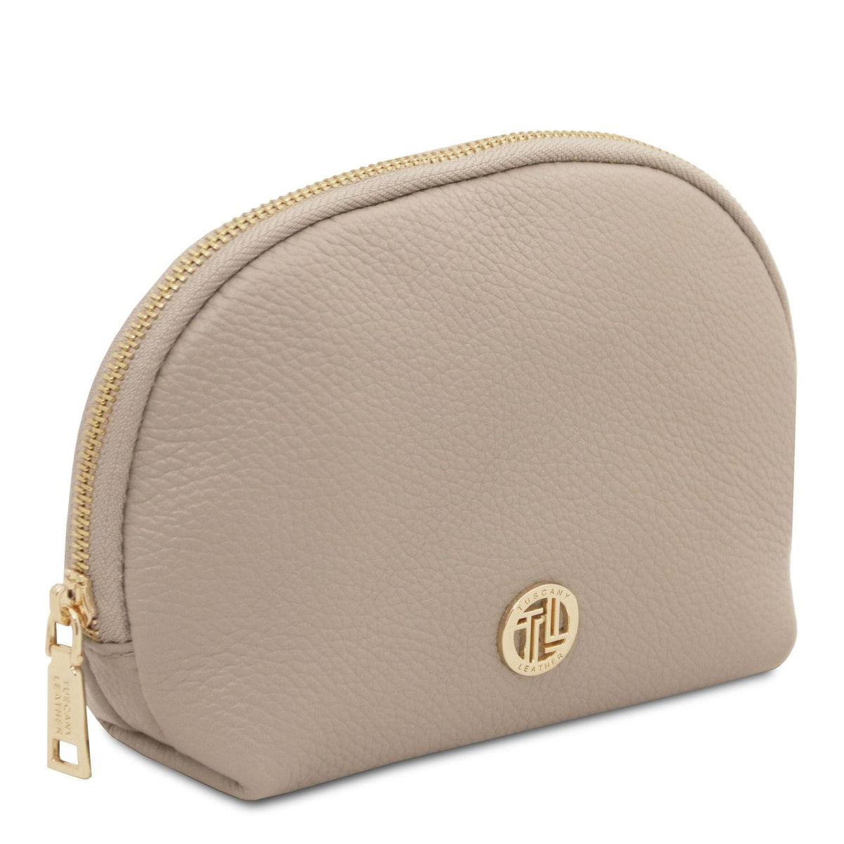 Soft taupe leather toiletry case with pebble grain texture, cremallera dorada, and round metal logo detail on front.